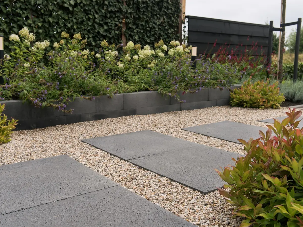 Grindpad met grote stapstenen langs een border met beplanting