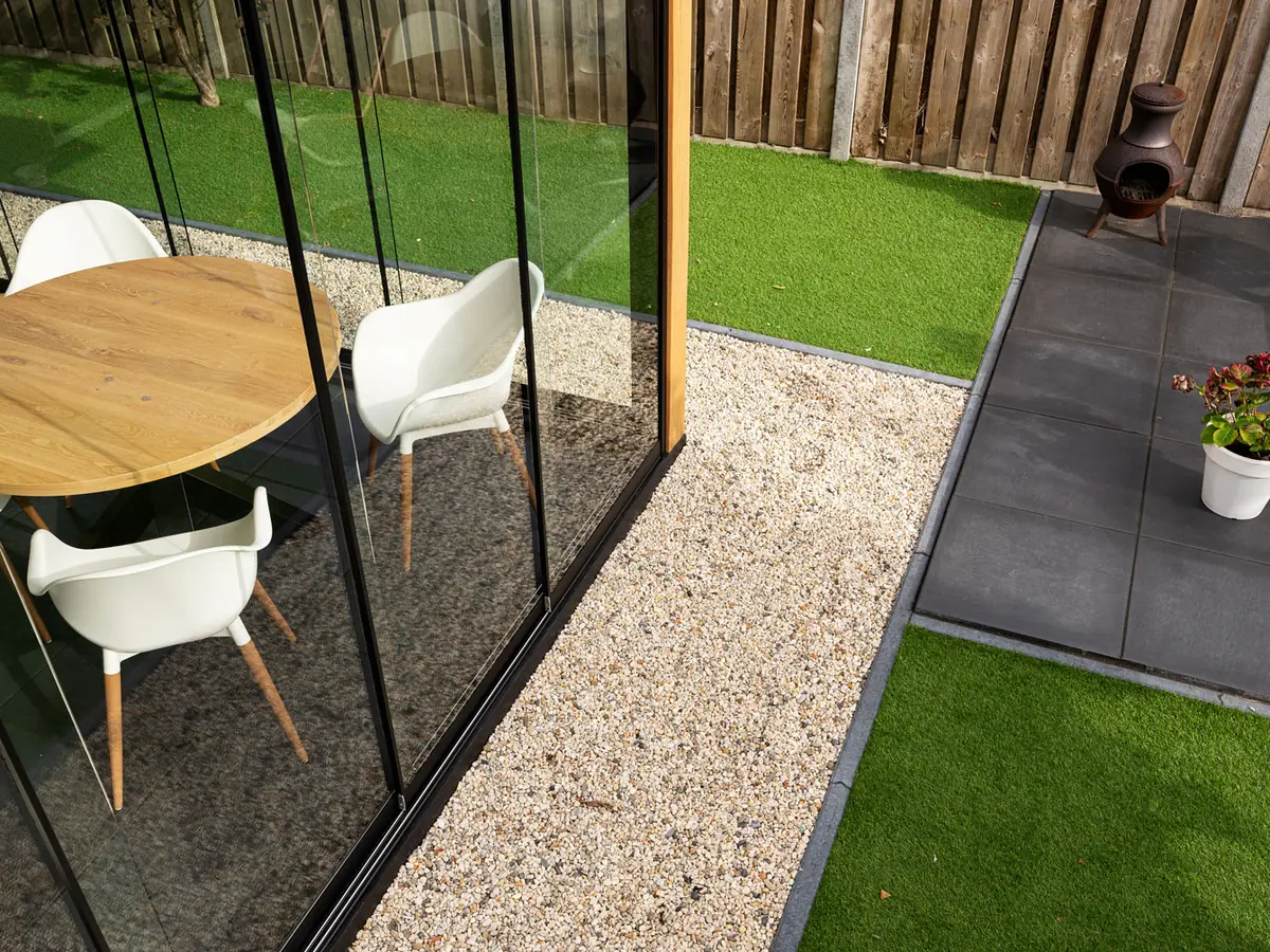 Onkruidvrij grindvlak langs een terras met eettafel